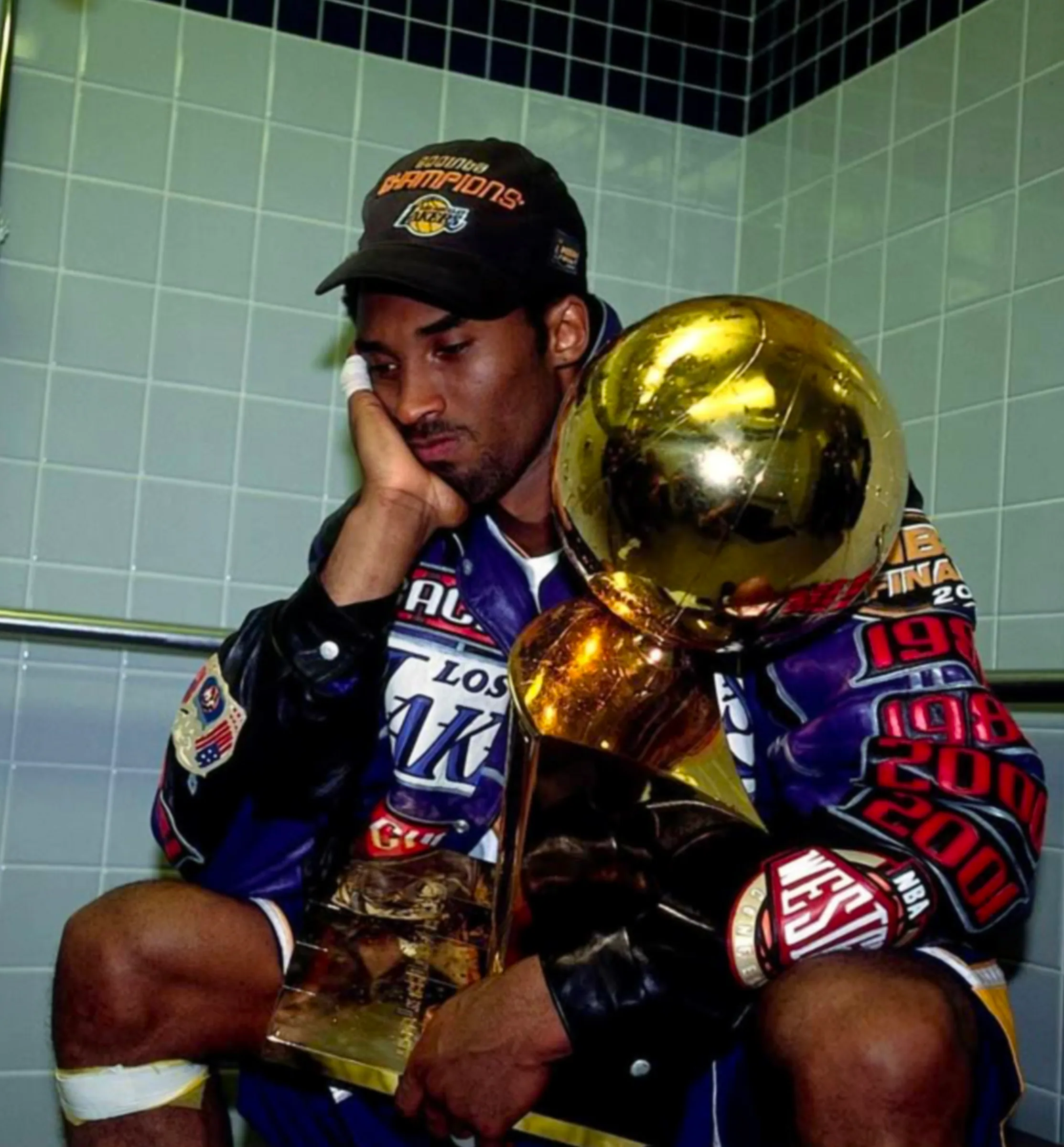 Kobe Bryant holding the championship trophy as visual reference